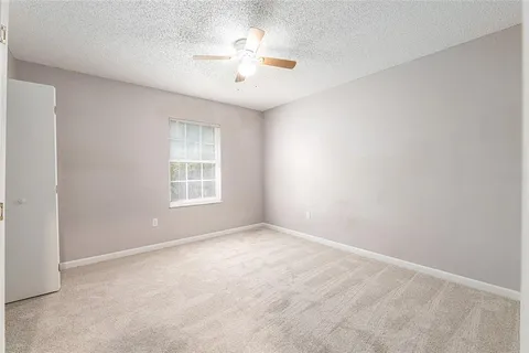 an empty room with fan and windows
