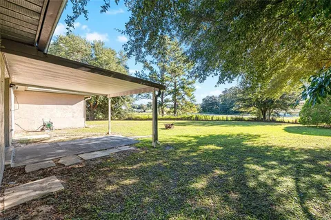 a view of swimming pool with yard and lake view