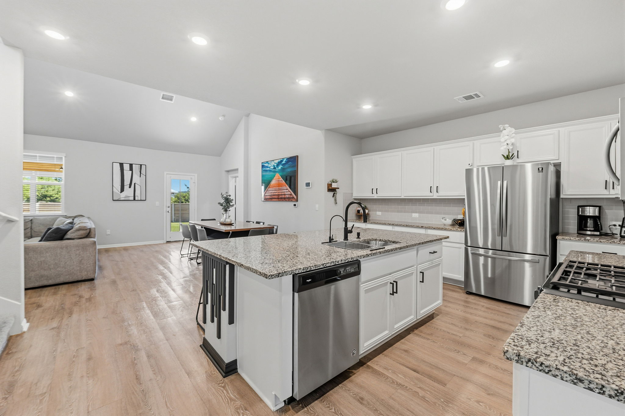 142 Brunnen Way Georgetown, TX 78626 - Photo 2 of 22 An inviting open-concept layout connects the well-appointed kitchen with its sun-drenched living and dining areas.