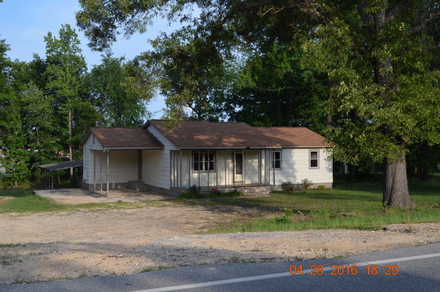 4684 Fulton Mill Road Macon, GA 31216 - Photo 1 of 16 a front view of a house with a garden and trees