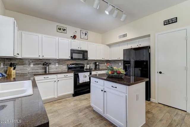 a kitchen with white cabinets and appliances