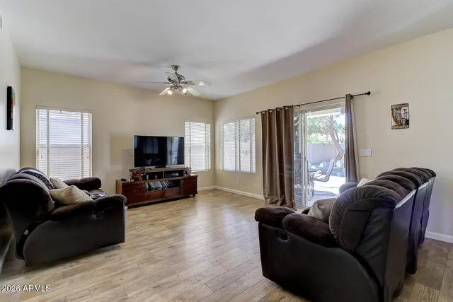 a living room with furniture ceiling fan and a flat screen tv