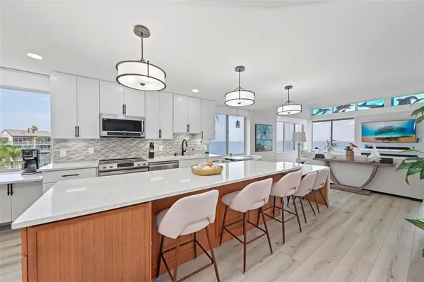 a kitchen with stainless steel appliances kitchen island granite countertop a dining table chairs and granite counter tops