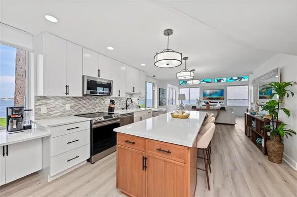 a kitchen with stainless steel appliances granite countertop a stove a sink and a microwave