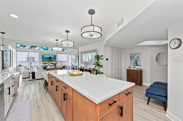 a kitchen with kitchen island granite countertop a sink a counter space appliances and cabinets