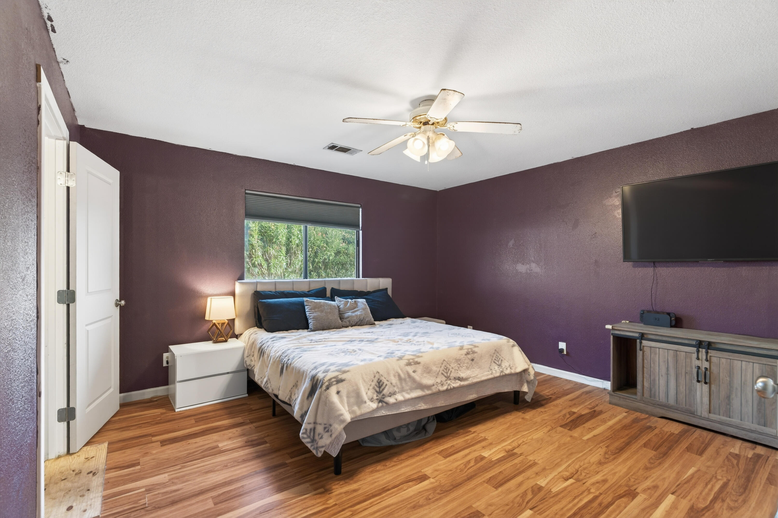 3733 Capricorn Way Redding, CA 96002 - Photo 14 of 22 a bedroom with a large bed and a flat tv screen on dresser