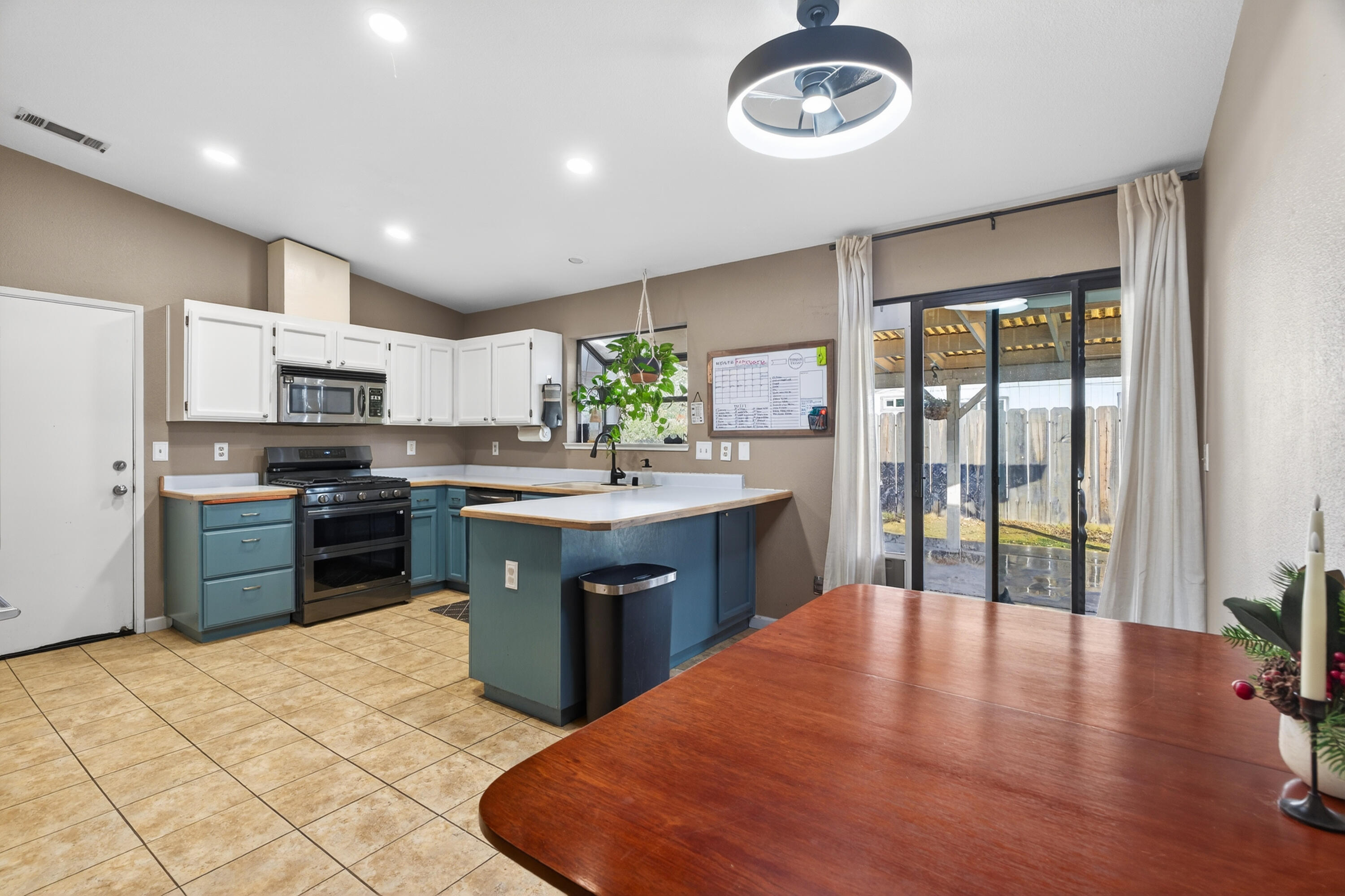 3733 Capricorn Way Redding, CA 96002 - Photo 5 of 22 a kitchen with stainless steel appliances granite countertop a stove top oven a sink dishwasher a dining table and chairs with wooden floor