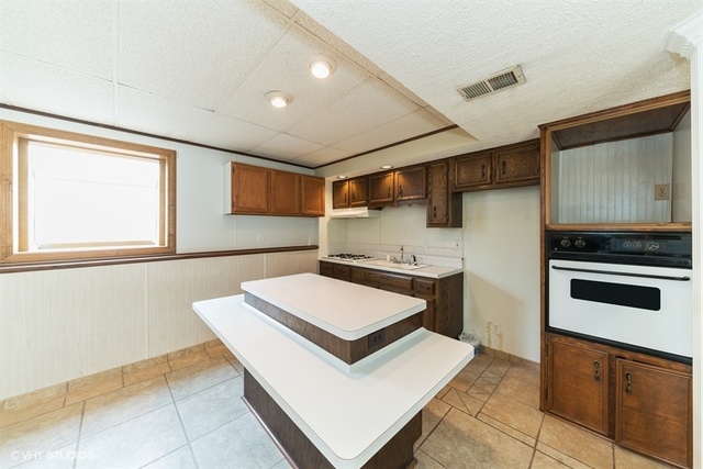 11S452 Book Road Naperville, IL 60564 - Photo 14 of 25 a kitchen with stainless steel appliances kitchen island granite countertop a stove and a sink