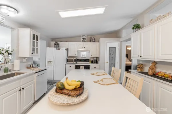 a large white kitchen with cabinets and stainless steel appliances