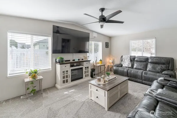 a living room with furniture a flat screen tv and a window