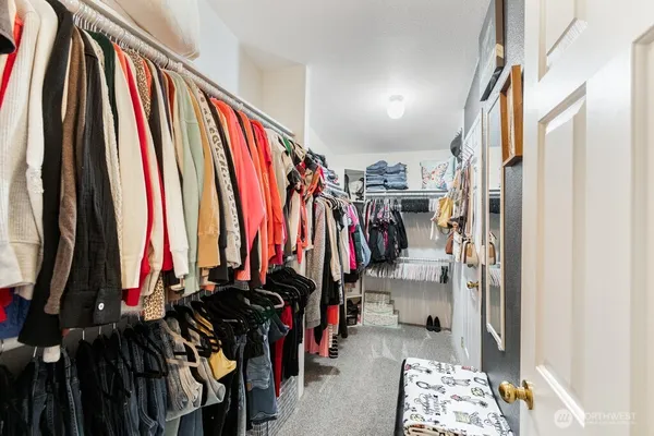 a view of walk in closet with clothes and shoes