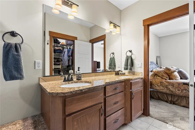 a en suite bathroom with a granite countertop sink and a mirror