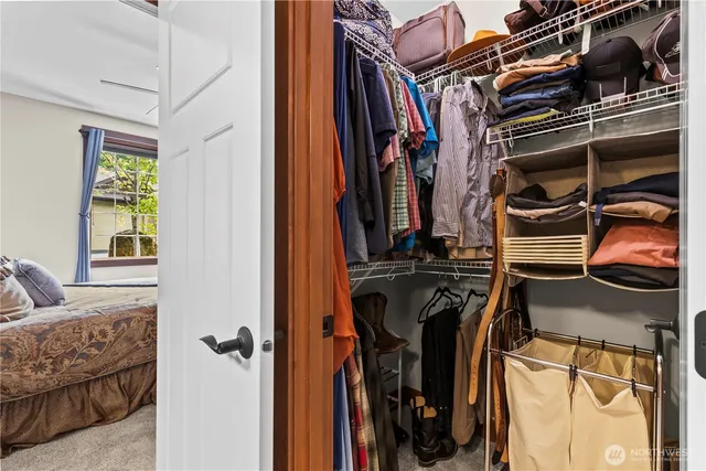 a view of walk in closet with clothes and shoes