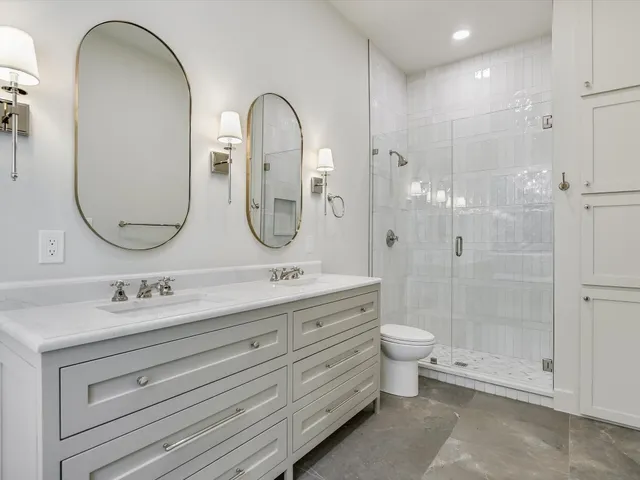 a bathroom with a double vanity sink toilet and shower