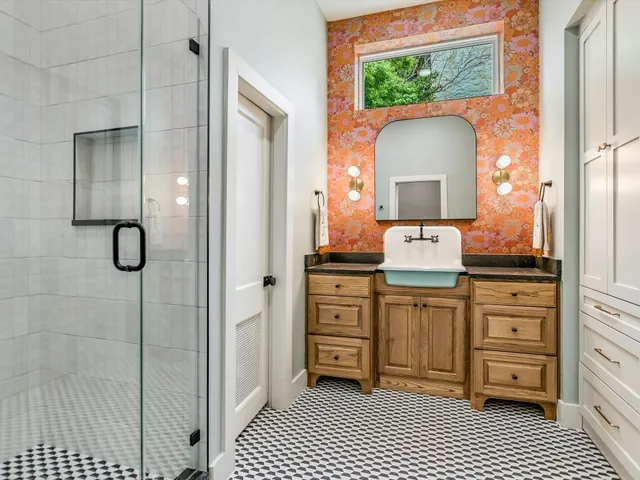 a spacious bathroom with a granite countertop sink a mirror and a shower