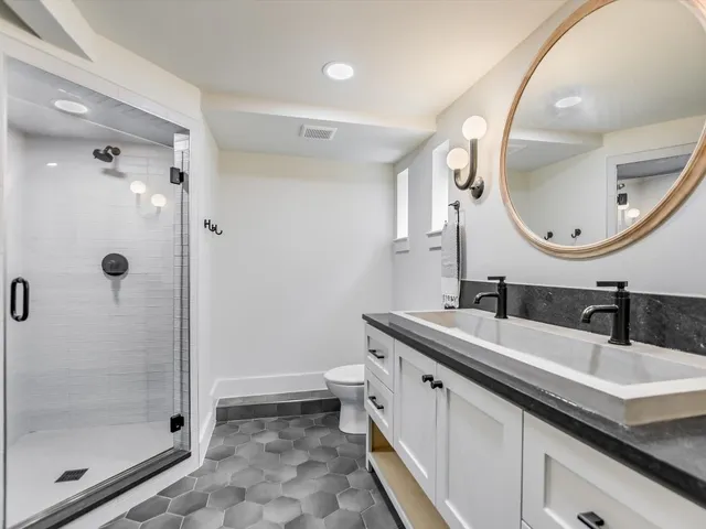 a bathroom with a granite countertop sink mirror and shower