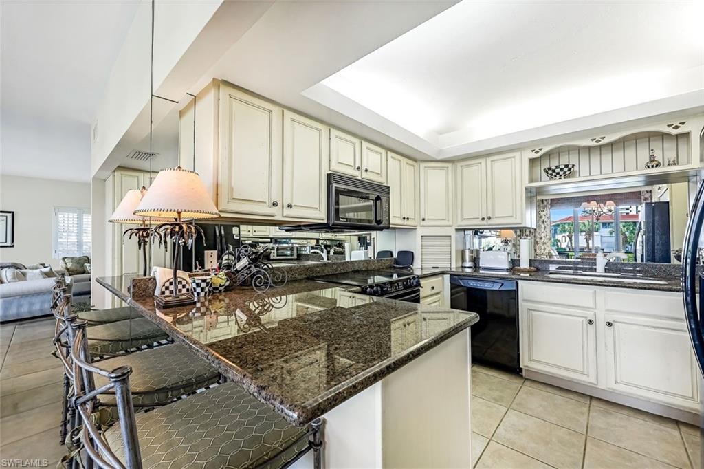2216 Gulf Shore Boulevard North, Unit R3 Naples, FL 34102 - Photo 7 of 16 a kitchen with a stove a sink and a microwave