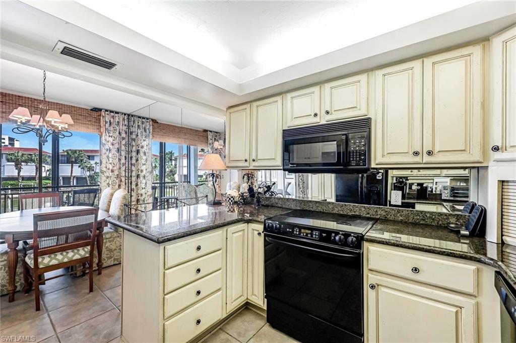 2216 Gulf Shore Boulevard North, Unit R3 Naples, FL 34102 - Photo 8 of 16 a kitchen with granite countertop a stove top oven microwave and cabinets