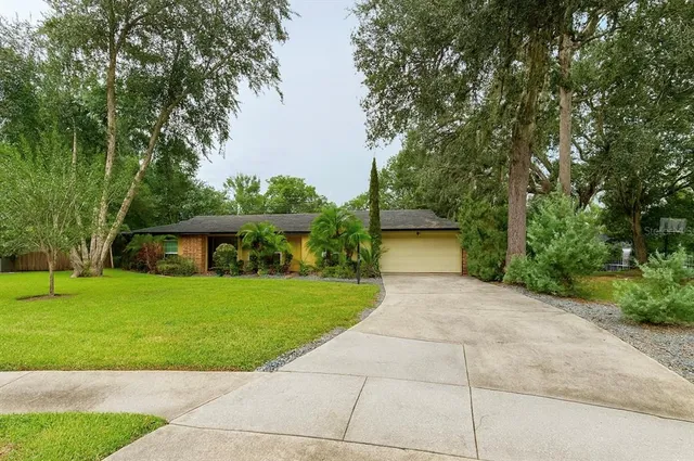 a front view of a house with a yard and trees