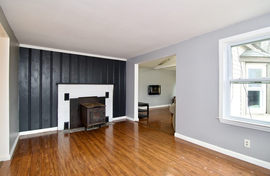 338 Wilbraham Road Hampden, MA 01036 - Photo 16 of 42 an empty room with wooden floor fireplace and windows