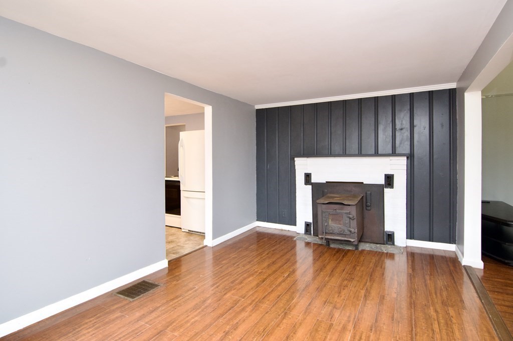 338 Wilbraham Road Hampden, MA 01036 - Photo 18 of 42 an empty room with wooden floor fireplace and windows