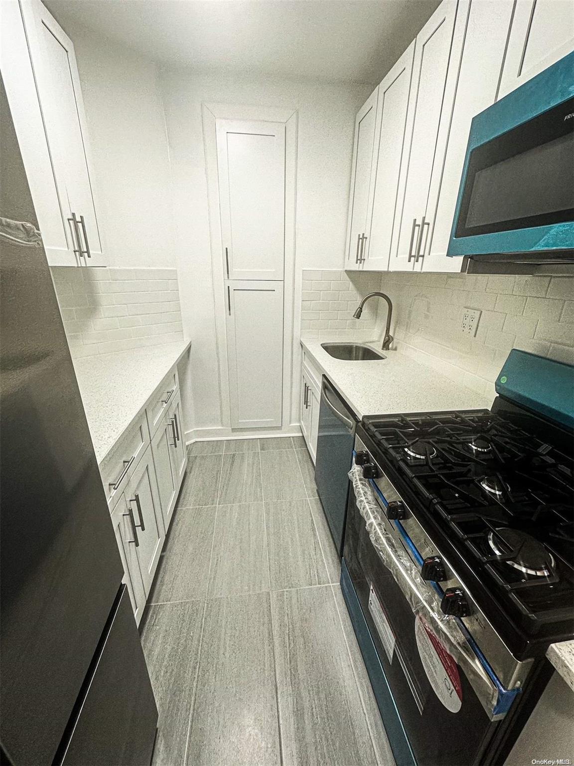 110-34 73rd Road, Unit 4C Queens, NY 11375 - Photo 2 of 10 a kitchen with wooden floors and a stove
