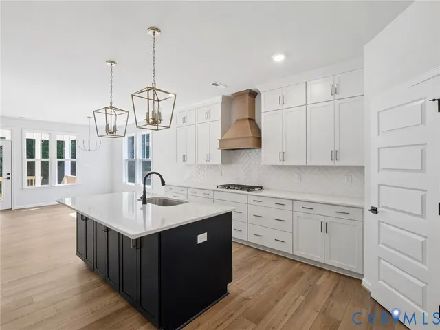 a kitchen with white cabinets and sink