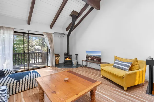 a living room with furniture a rug and a floor to ceiling window