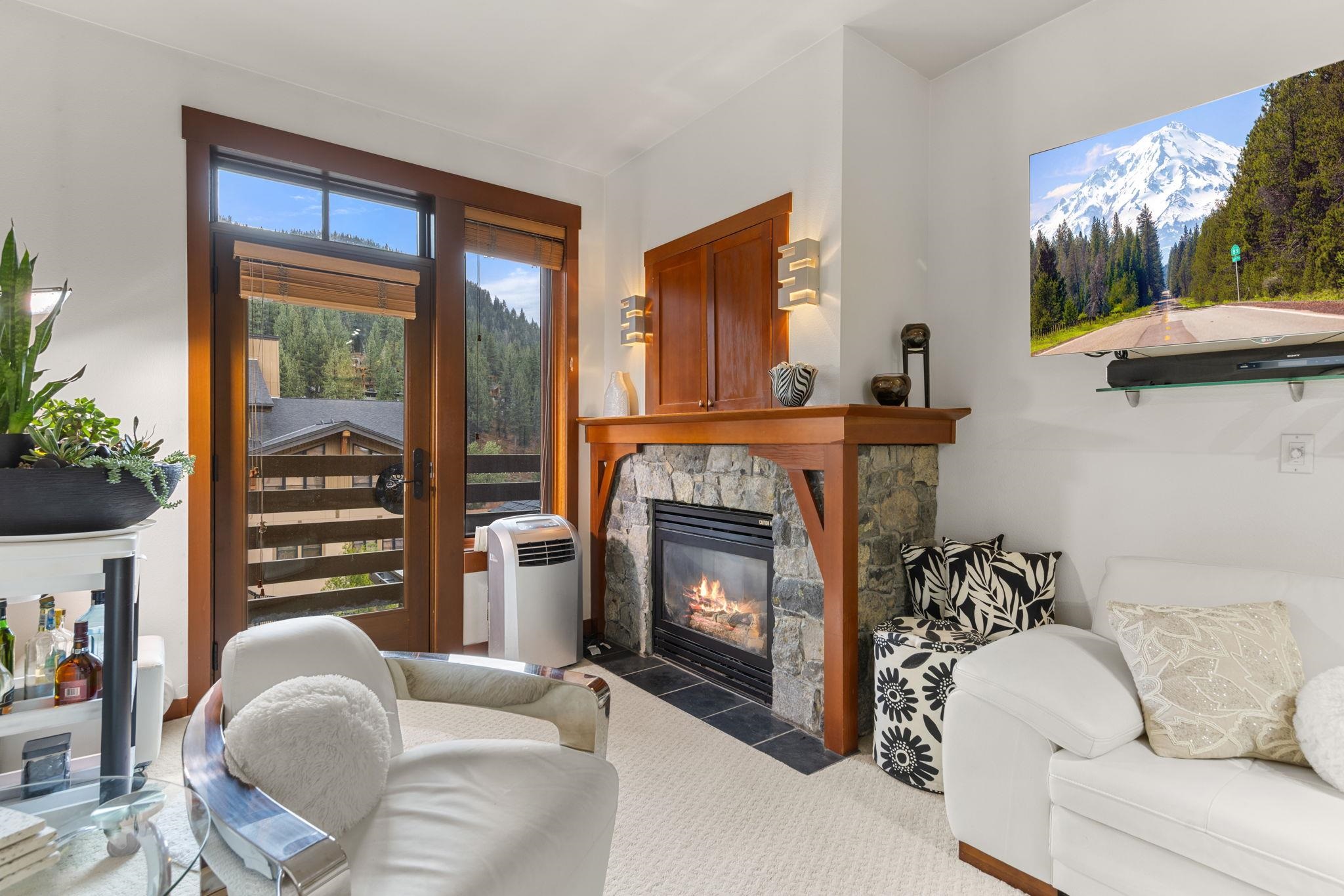 1750 Village East Road, Unit 409 (5409) Olympic Valley, CA 96146 - Photo 7 of 27 a living room with furniture a flat screen tv and a fireplace