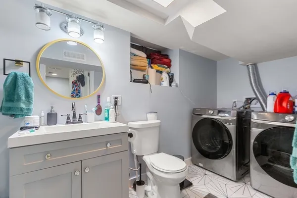 a bathroom with a toilet sink and mirror