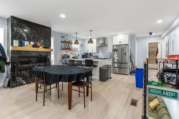 a open kitchen with stainless steel appliances granite countertop a table chairs and a refrigerator