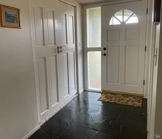 an entryway with wooden floor and a cabinet