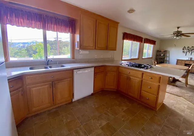 a kitchen with stainless steel appliances granite countertop a refrigerator a sink a stove a microwave a counter space and cabinets