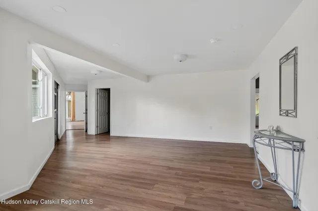 a view of a room with wooden floor and white walls