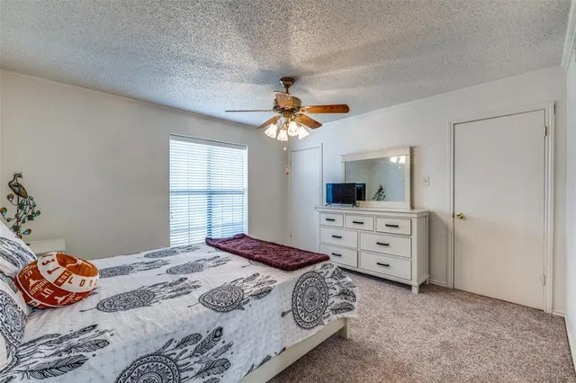 a bedroom with a bed a dresser and a chandelier