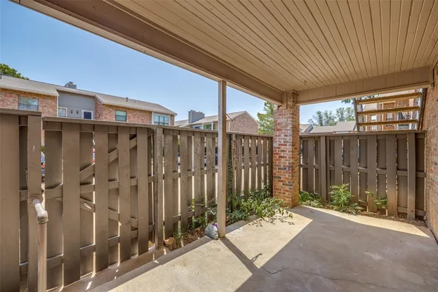 a view of a patio with table and chairs with wooden fence and plants