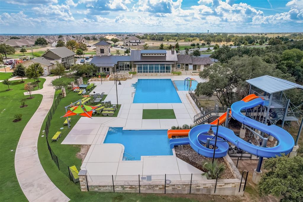 124 Ribera Drive Liberty Hill, TX 78642 - Photo 37 of 40 An aerial perspective reveals a vibrant community pool area, complete with engaging waterslides and a nearby clubhouse.