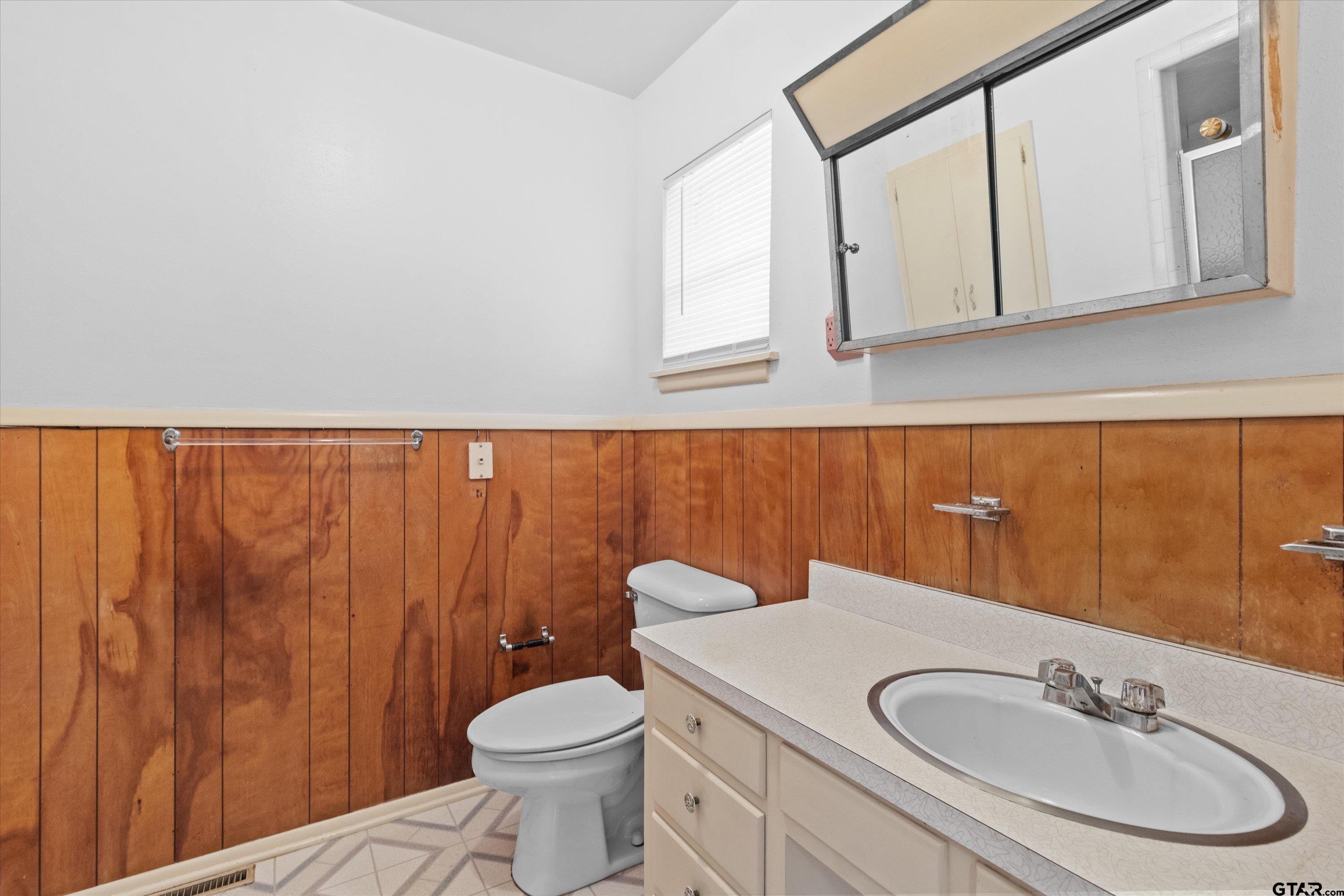 4168 Gallion Avenue Tyler, TX 75708 - Photo 16 of 27 a bathroom with a sink a toilet and mirror