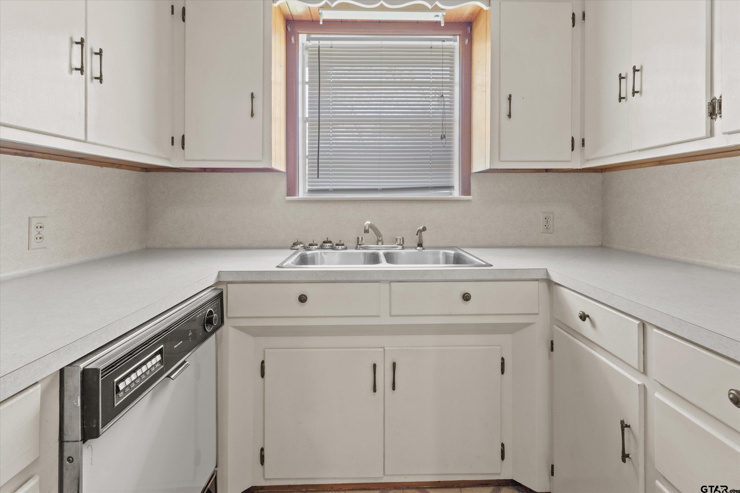 4168 Gallion Avenue Tyler, TX 75708 - Photo 9 of 27 a kitchen with white cabinets and a sink