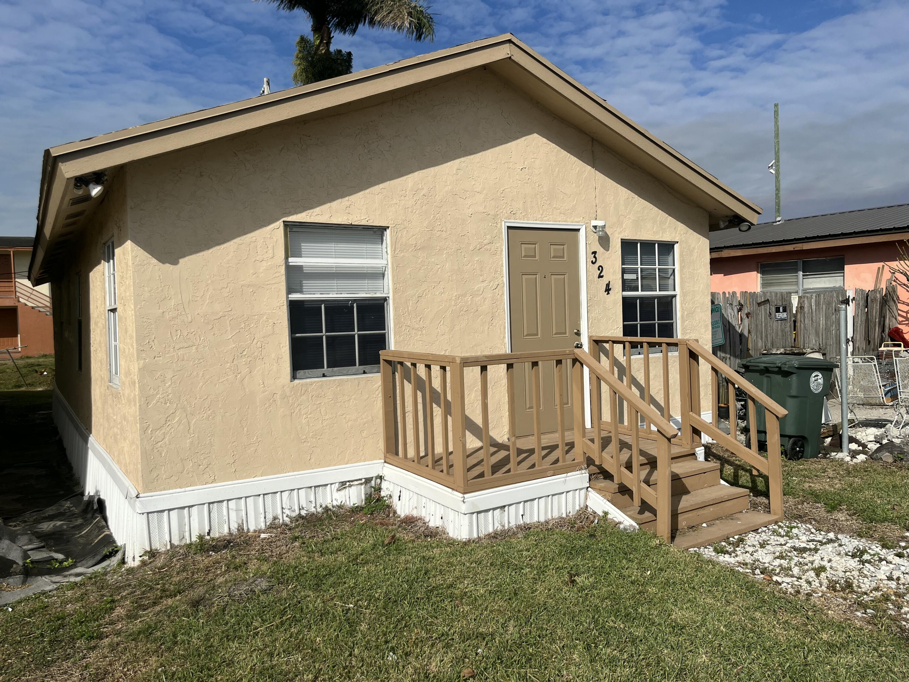 a view of wooden house with a small yard