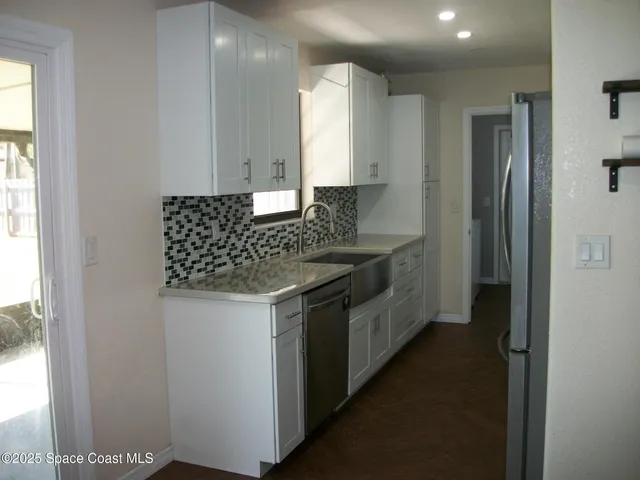 a kitchen with stainless steel appliances granite countertop a sink and a refrigerator