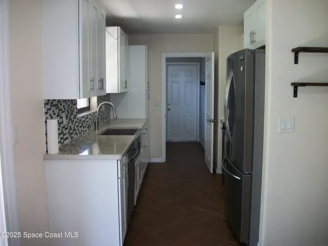 a kitchen with a refrigerator and a sink