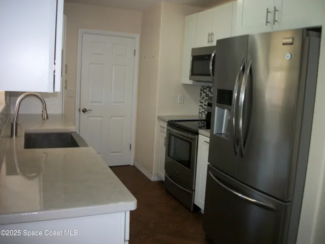 a kitchen with metallic refrigerator and stove