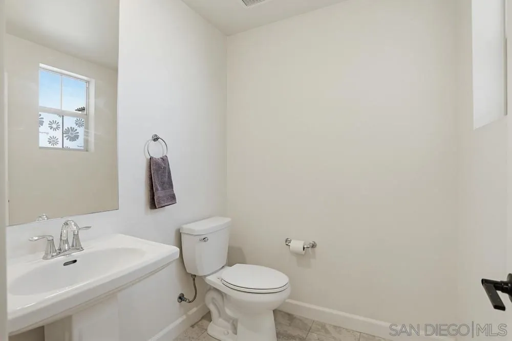 4373 Pacifica Way, Unit 6 Oceanside, CA 92056 - Photo 18 of 48 a bathroom with a toilet sink and mirror