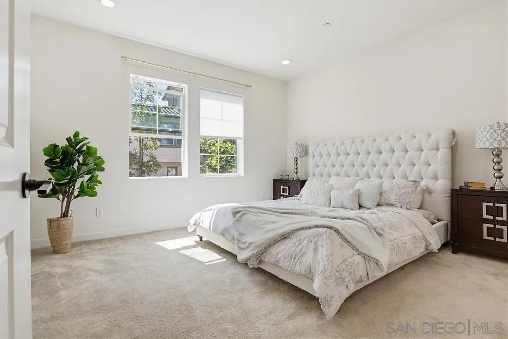 4373 Pacifica Way, Unit 6 Oceanside, CA 92056 - Photo 20 of 48 a spacious bedroom with a bed and a potted plant