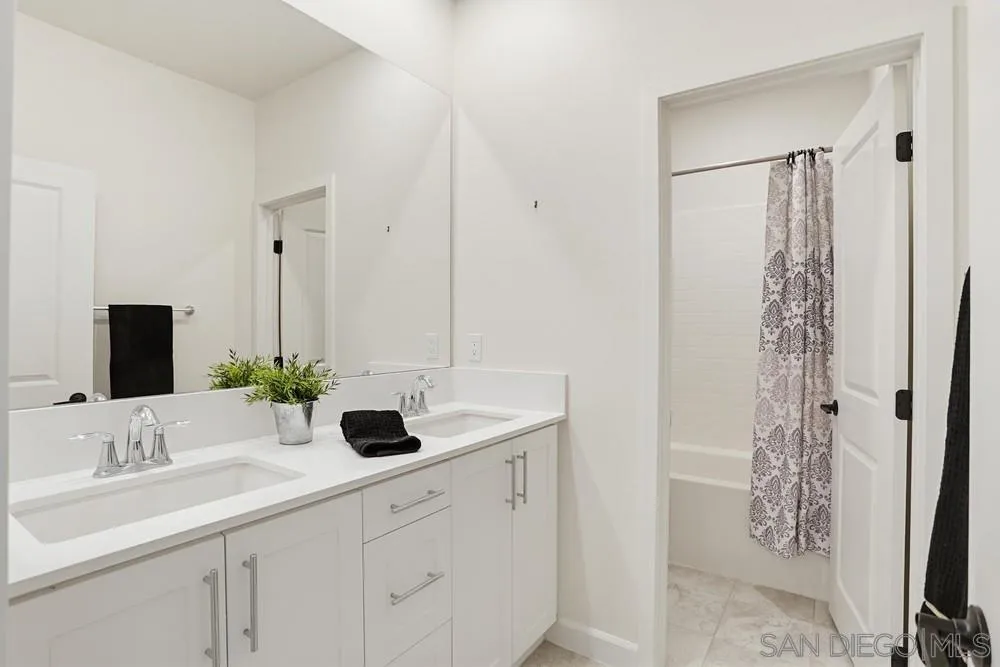 4373 Pacifica Way, Unit 6 Oceanside, CA 92056 - Photo 33 of 48 a bathroom with a double vanity sink and mirror