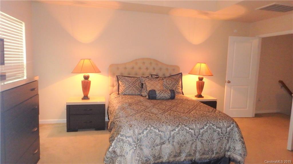913 Rook Road Charlotte, NC 28216 - Photo 14 of 22 a bedroom with a bed and a lamp