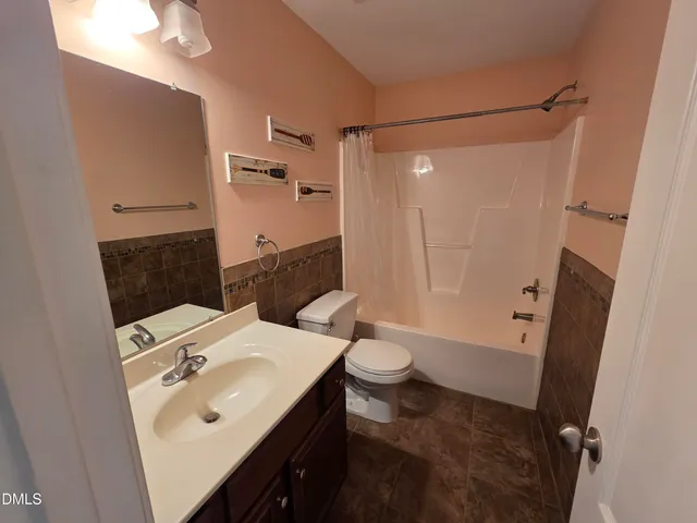 a bathroom with a sink and mirror with toilet