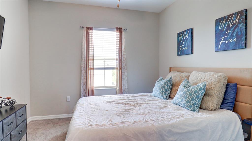 31632 Blue Passing Loop Wesley Chapel, FL 33545 - Photo 38 of 48 a large bed in a bedroom next to a window