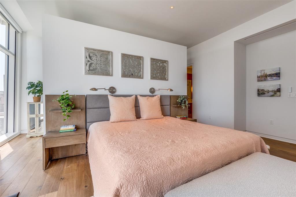 1918 Olive Street, Unit 701 Dallas, TX 75201 - Photo 15 of 40 a bedroom with a large bed and a wooden floor